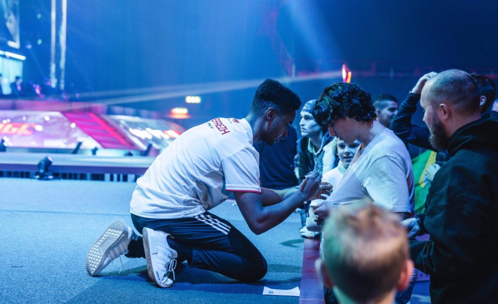 Refrezh kneeling down to sign a fan's jersey at PGL Stockholm CS: GO Major in 2021.