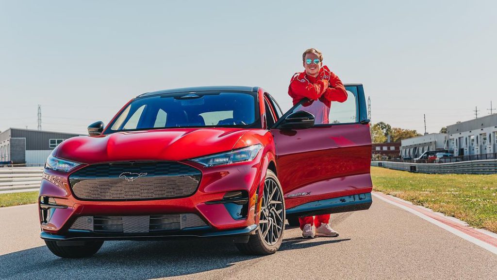 Chief Pat posing with a Ford vehicle. 