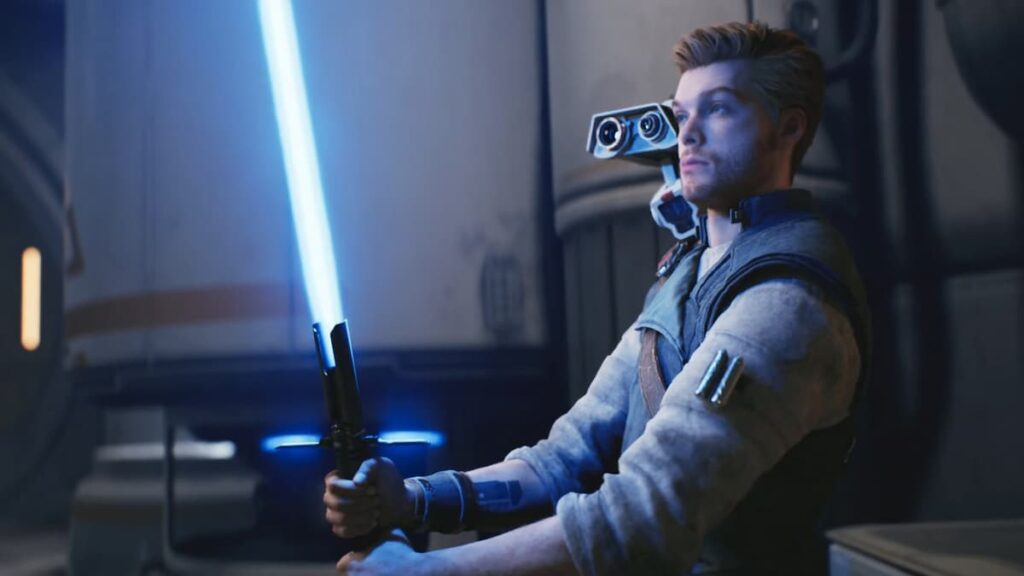 Cal Kestis, with his BD droid on his shoulder, ignites a cross guard lightsaber with a blue crystal.