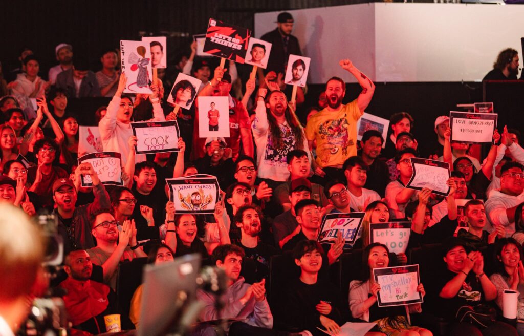 Fans in audience cheer with signs during Week 7 of 2023 VCT Americas at the Riot Games Arena on May 13, 2023.