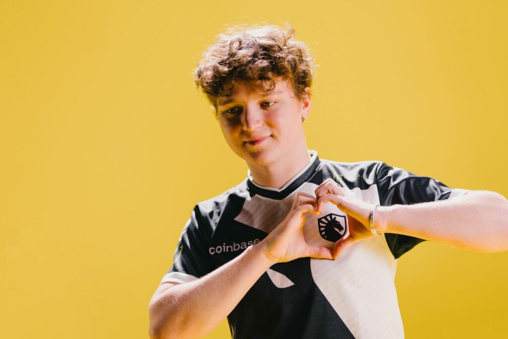 YEKINDAR with a heart shape using his hands against a Yellow background. 