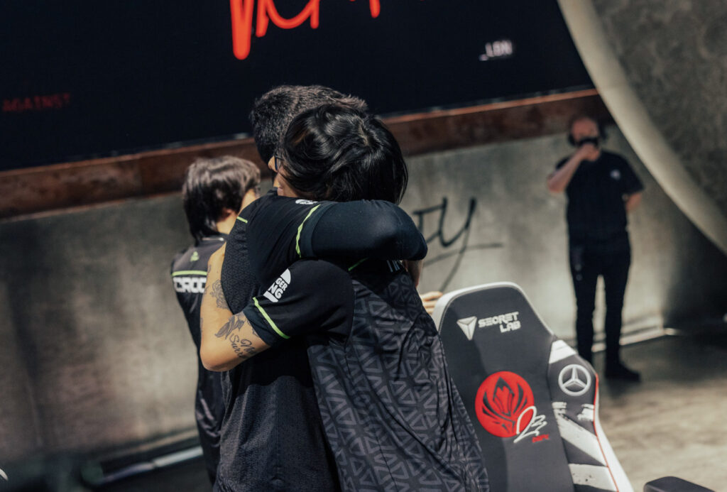 Tinowns and Robo hugging on stage after a win - image via Colin Young-Wolff/Riot Games