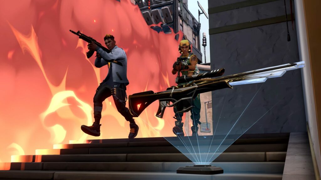 Phoenix and Raze walk down a set of stairs with Phoenix's wall covering them and an Operator pickup in front of them.