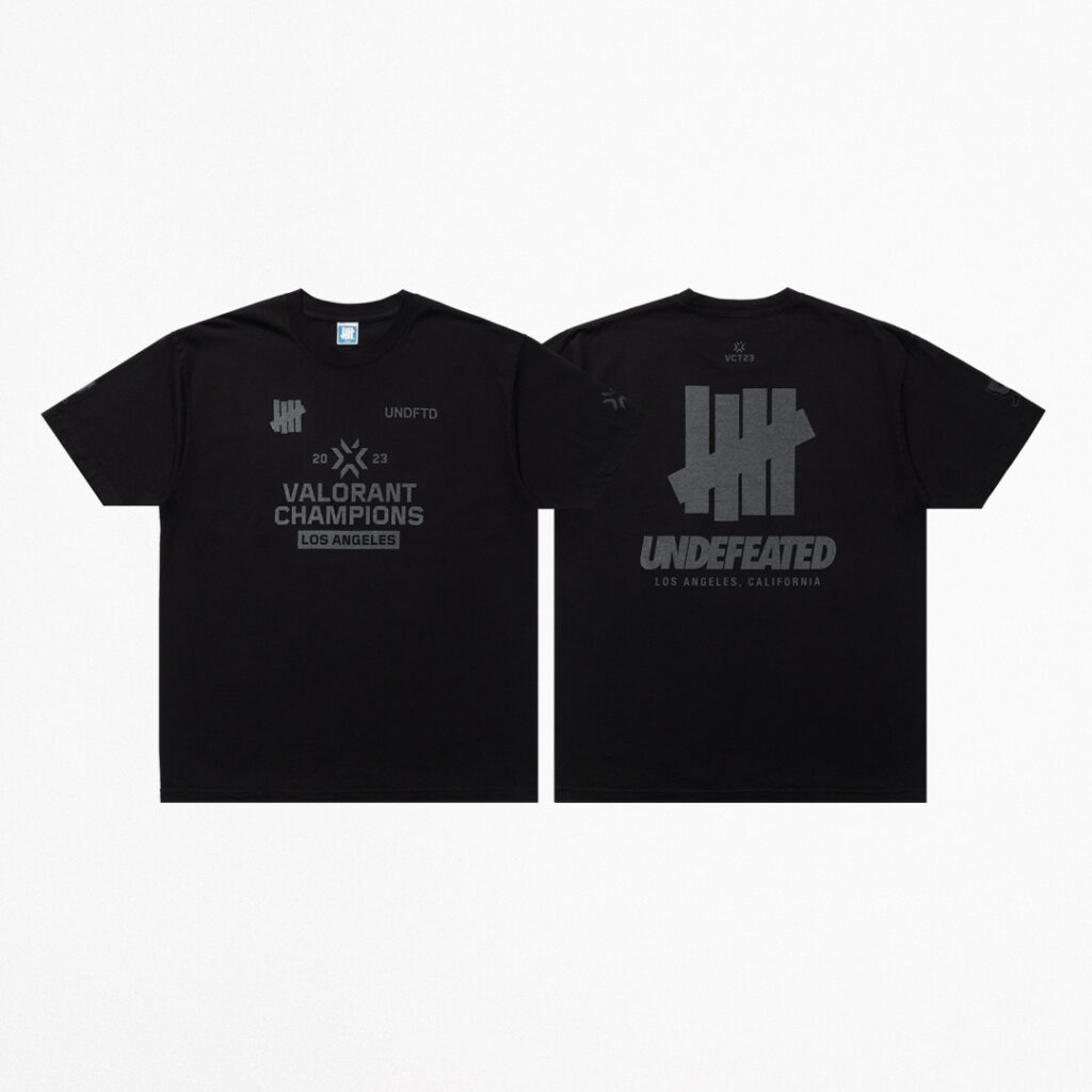 The front and back of the black short-sleeve tee from the VALORANT Champions x UNDEFEATED capsule collection.