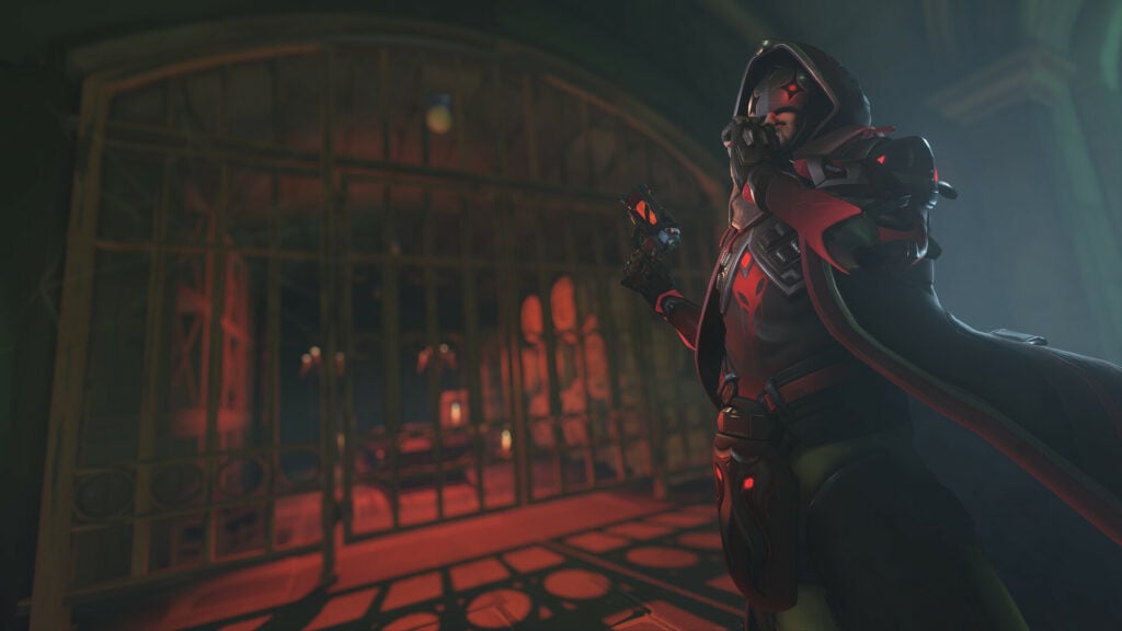 An image of Reaper in a dark dungeon with reddish hues. Reaper has his finger on hs lips suggesting to keep quiet.