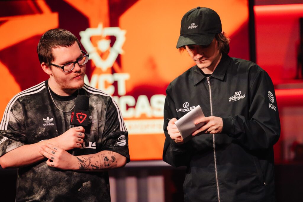 Boostio (L) and coach “Zikz” of 100 Thieves speak onstage before competing during VCT Americas Mid-Season Finals at the Riot Games Arena on May 12, 2024. 