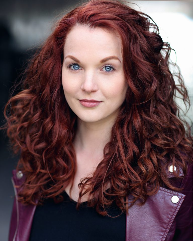 White woman with long red hair.