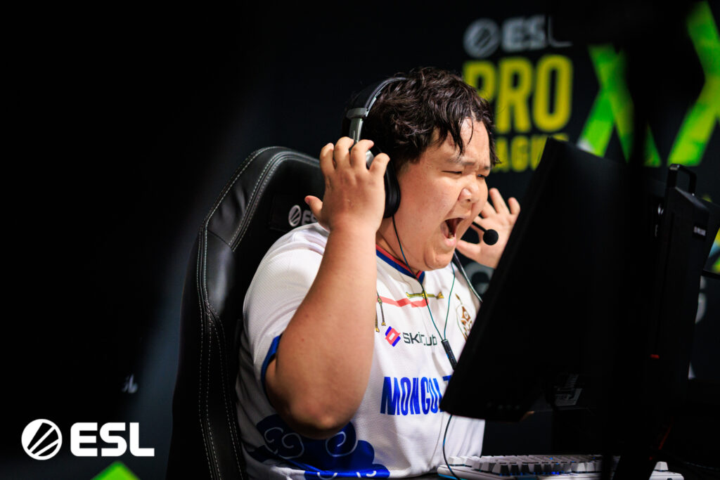 Counter-Strike player Mzinho celebrates and is in the process of removing his headphones