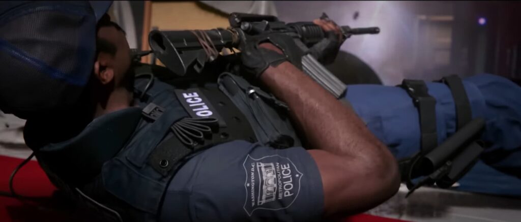 A character from the Call of Duty: Black Ops 6 campaign dives backwards, lands on the ground, and fires his weapon.