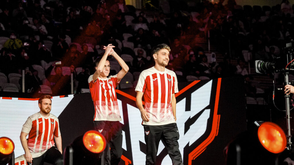 Three male players walking on a stage with HEROIC jerseys.