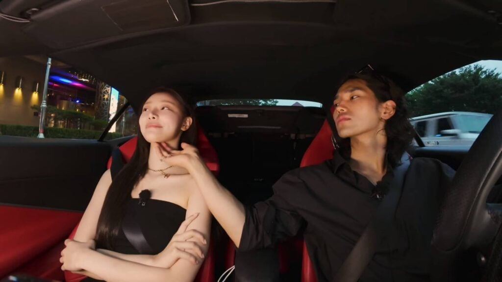 The image shows a sweet moment between two Single’s Inferno Season 4 contestants: in Episode 9, Yuk Jun-seo torches Lee Si-an’s chin while they are in a car.