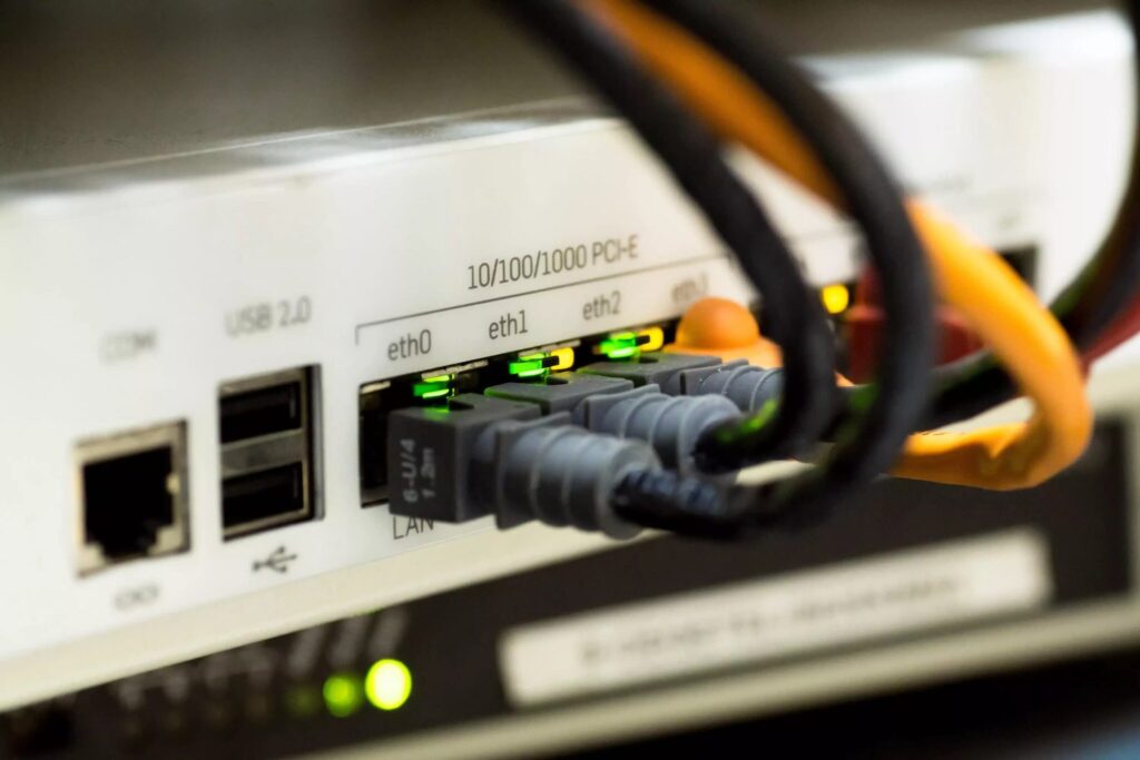 An ethernet cable runs from a router to reduce ping in games
