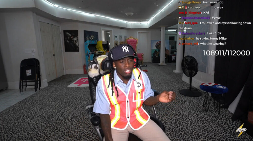 Kai Cenat explains the Twitch hack to his stream from his room.