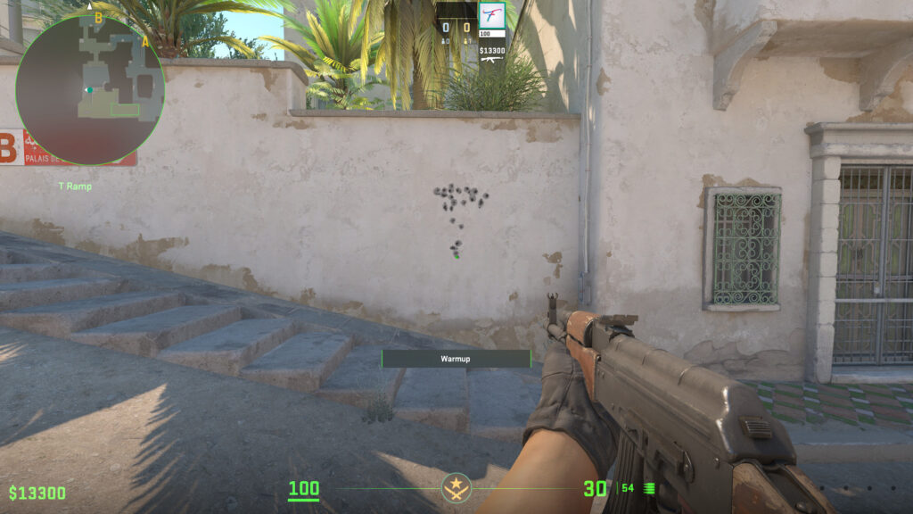 A player holds an AK-47 and shoots at a wall in CS2.