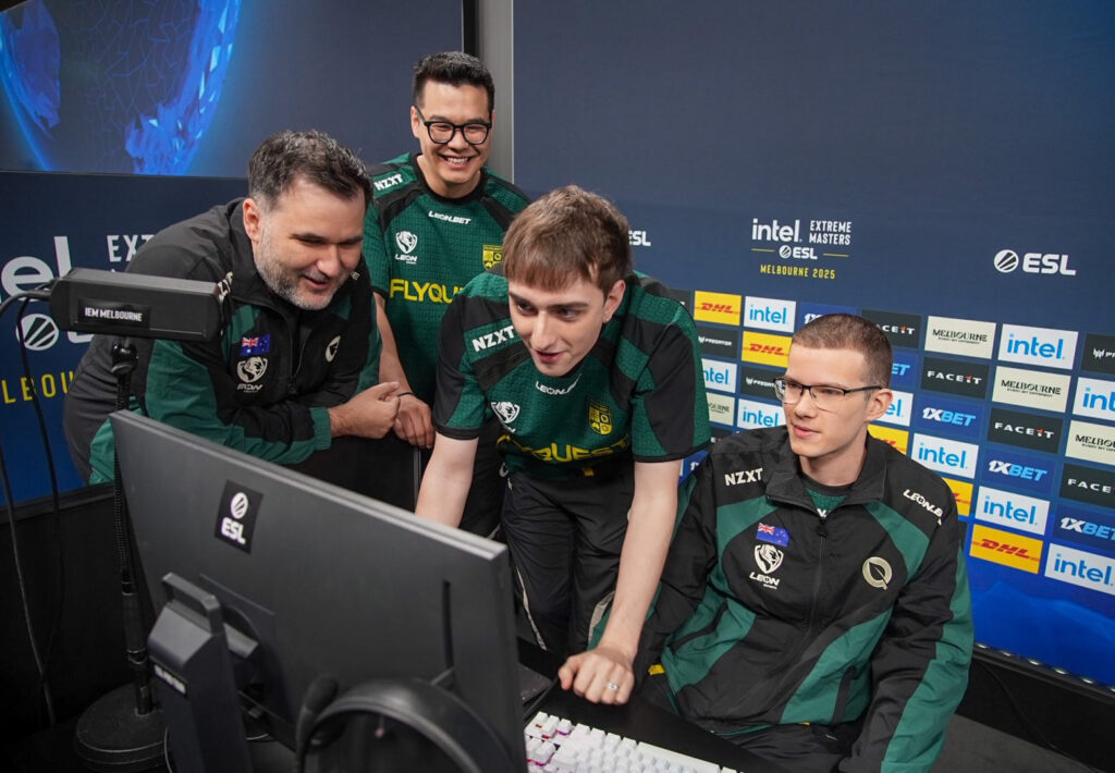 The FlyQuest team crowd around nettik's PC at IEM Melbourne.