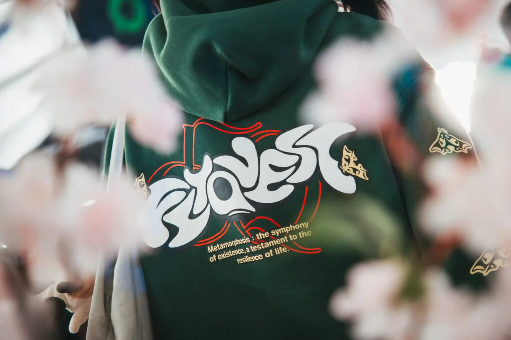 A FlyQuest hoodie surrounded by cherry blossom petals.