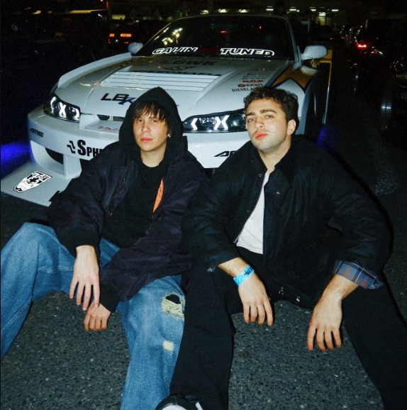 Kole from Tokyo Sims and Mizkif sitting infront of a sports car