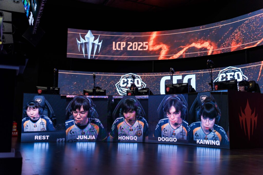 The photo features the LoL esports players from the team CTBC Flying Oyster during the grand final of the regional League of Legends tournament LCP 2025 Mid Season - everyone plays on their computers, their faces and names are shown on separate monitors.