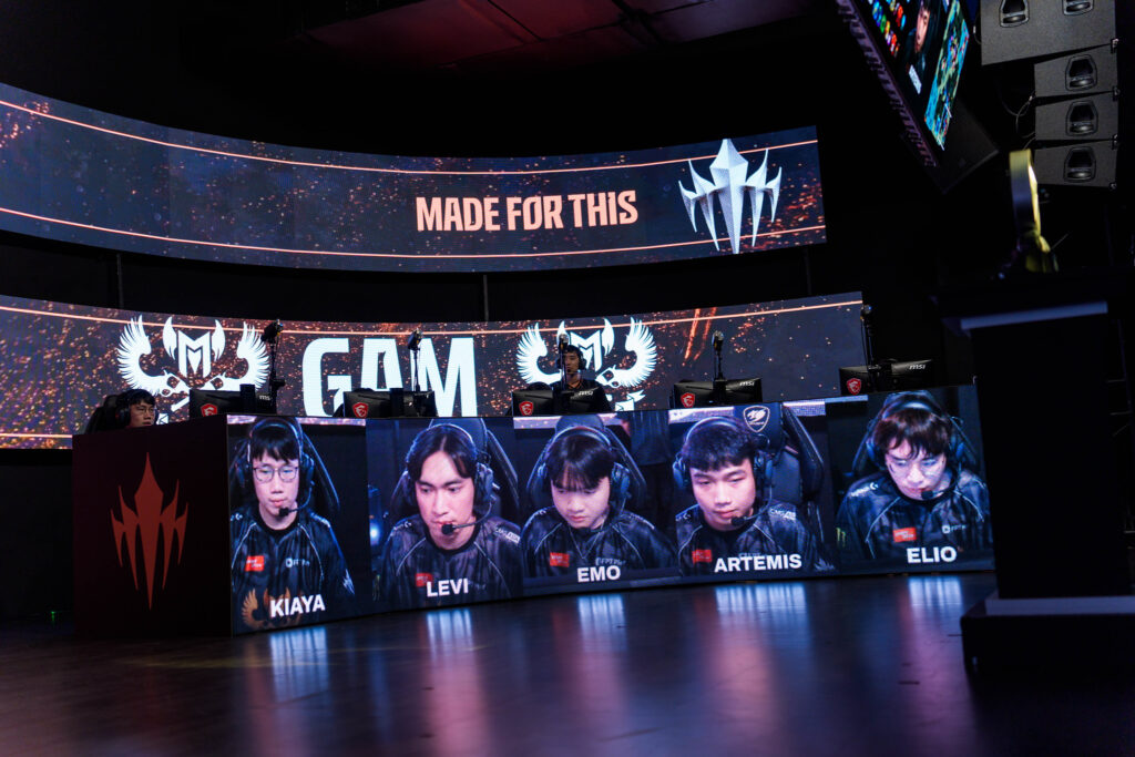 The photo features the LoL esports players from the team GAM Esports during the grand final of the regional League of Legends tournament LCP 2025 Mid Season - everyone plays on their computers, their faces and names are shown on separate monitors.