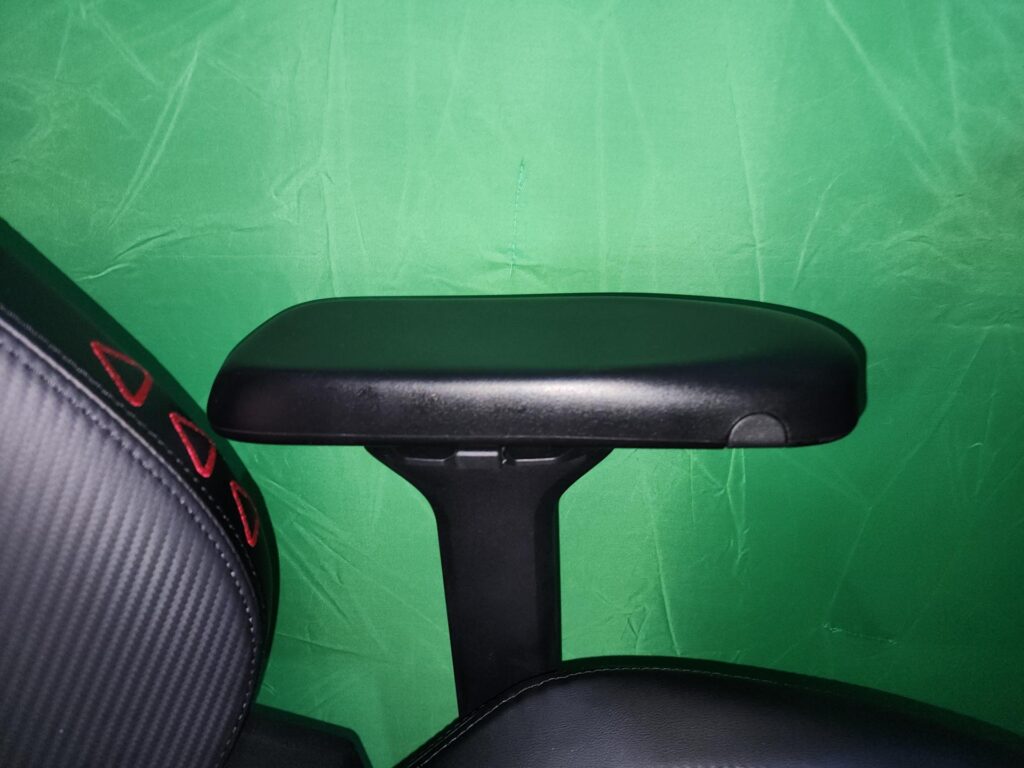 The armrest has three buttons for adjustment, two of which are visible here. (Photo via esports.gg)