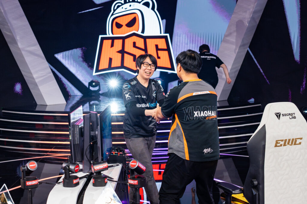 It’s a photo of two fighting games players GO1 and Xiaohai shaking hands before a match at the Street Fighter 6 Esports World Cup 2025.