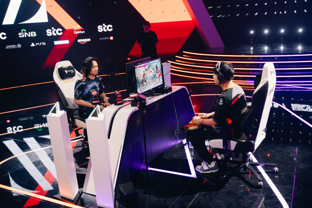 It’s a photo of two fighting games players Kakeru and Xiaohai shaking hands before a match at the Street Fighter 6 Esports World Cup 2025.