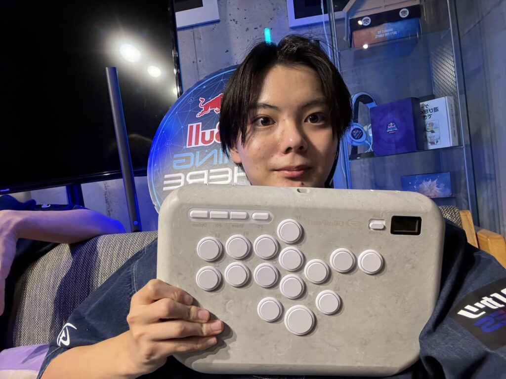 The Street Fighter player Sahara holds a leverless fighting controller - a photo.