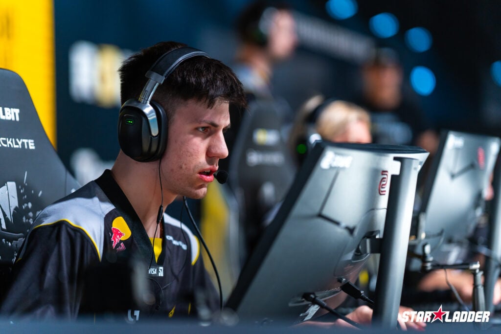 The CS2 esports player b1t from the team NAVI is smiling in front of his computer during Stage 2 at the StarLadder Budapest Major 2025 - a photo.