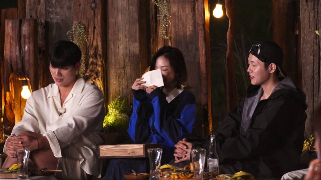 The screenshot from Netflix’s show Single’s Inferno Season 5: Shin Hyeon-woo, Kim Go-eun, and Woo Sung-min near a campfire in episode 4.