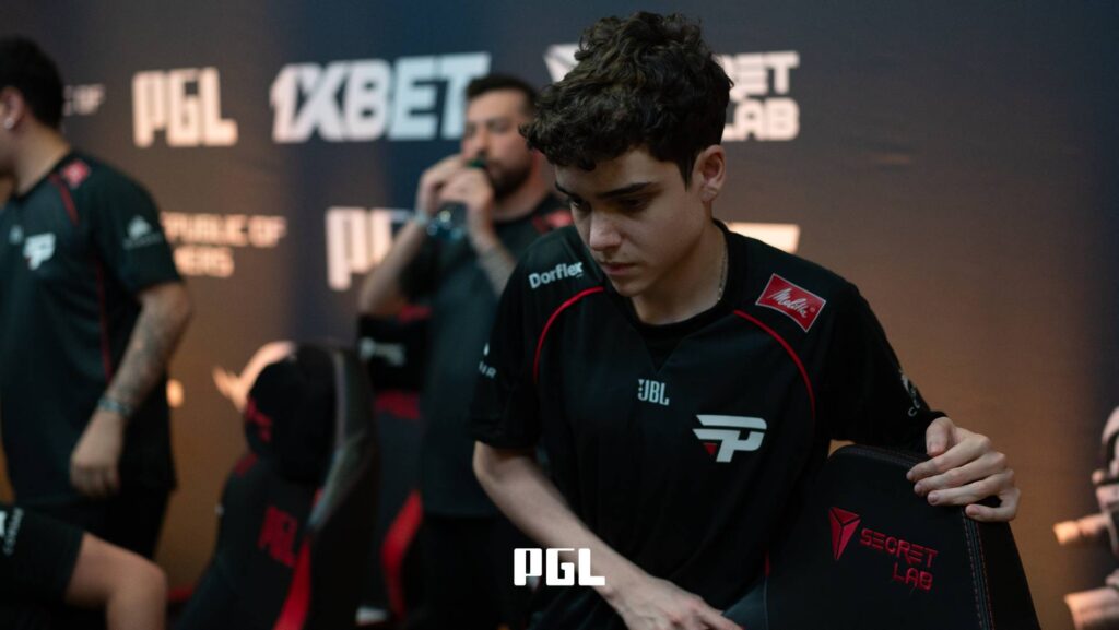 It’s a photo of Counter-Strike 2 esports player João "snow" Vinicius from the team paiN Gaming during the Swiss Stage of the CS2 tournament PGL Cluj-Napoca 2026 — a big sad, collecting his stuff after a match.