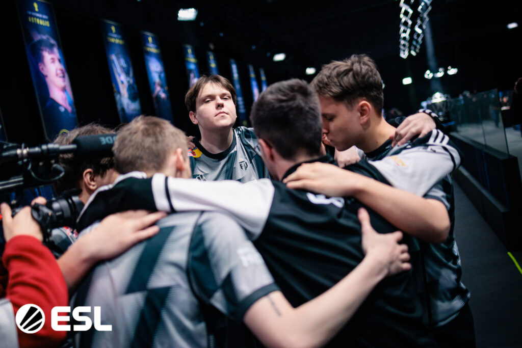 It’s a photo of the Counter-Strike players from the team FUT Esports on the stage at the CS2 event IEM Kraków 2026: pre-match team hugs.