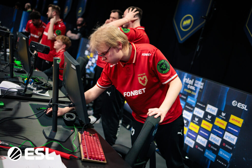 It's a tournament photo of the CS2 team MOUZ at IEM Krakow 2026: preparation for a match during the Group Stage.