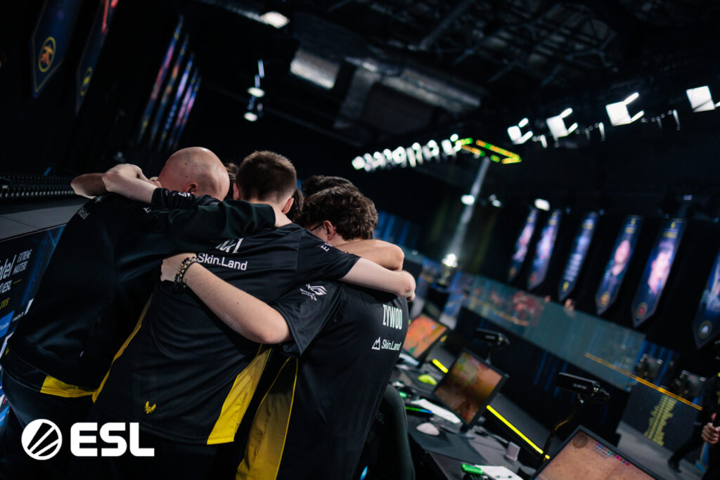 It's a tournament photo of the CS2 esports Team Vitality at IEM Krakow 2026: during team-bonding hugs. 
